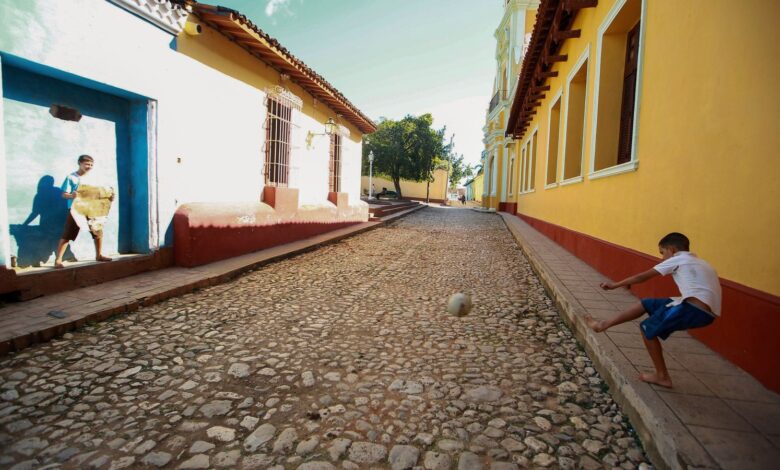 Dos chicos juegan al fútbol en una calle de barrio, una imagen que remite a los inicios de Messi