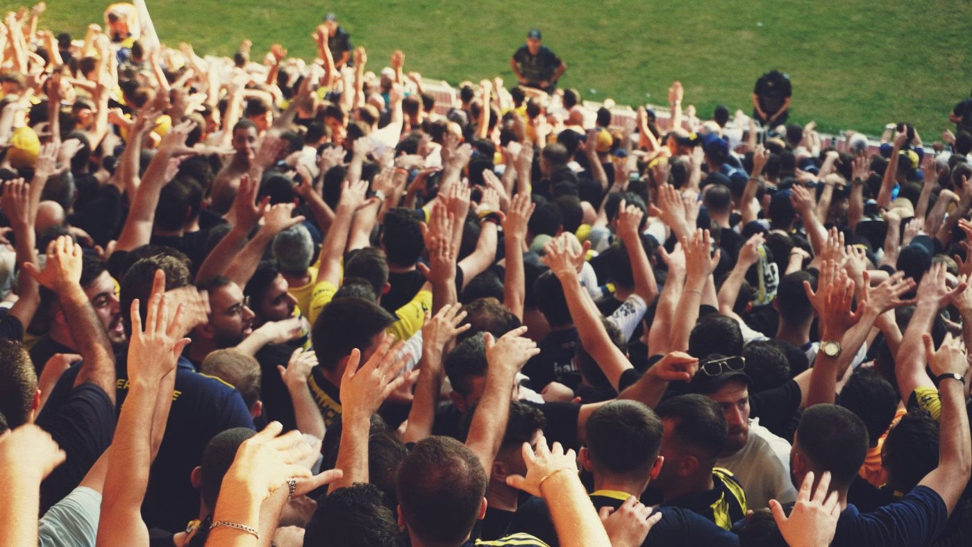 Hinchas levantando los brazos en una tribuna