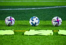 Pelotas de fútbol sobre el césped de una cancha