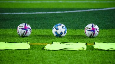 Pelotas de fútbol sobre el césped de una cancha