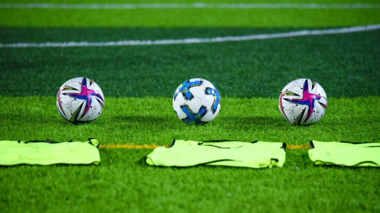 Pelotas de fútbol sobre el césped de una cancha