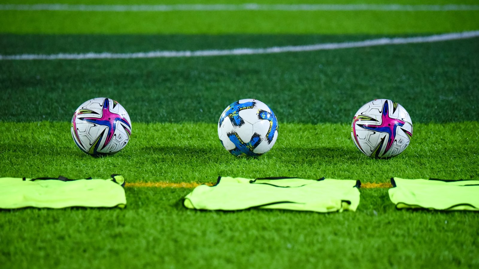 Pelotas de fútbol sobre el césped de una cancha