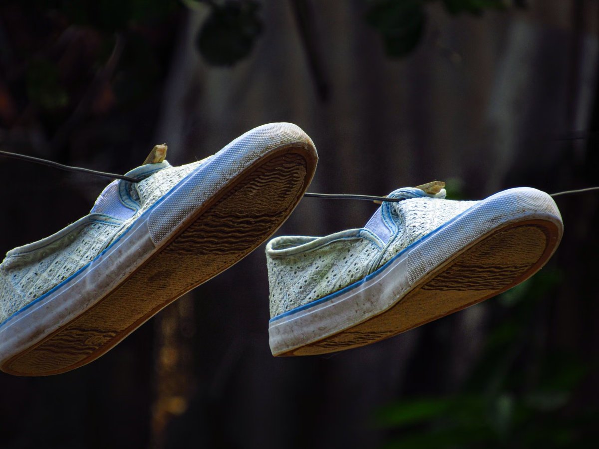 Par de zapatillas de lona colgadas de una soga para que se sequen