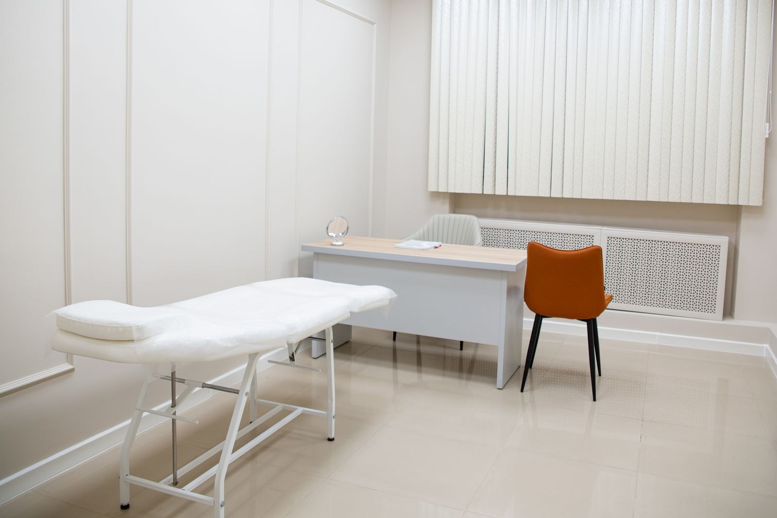 Consultorio médico con camilla, escritorio y silla
