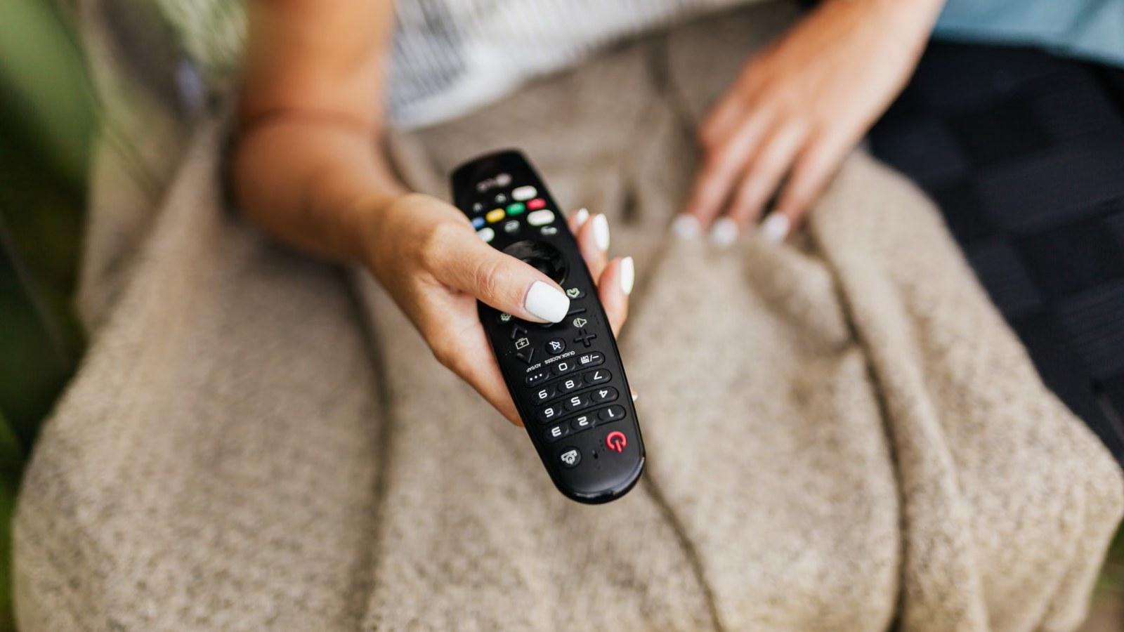 Mano sosteniendo un control remoto de televisión
