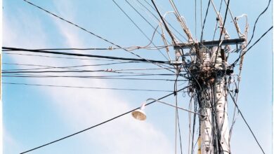 Poste de luz con cables de tendido eléctrico contra el cielo
