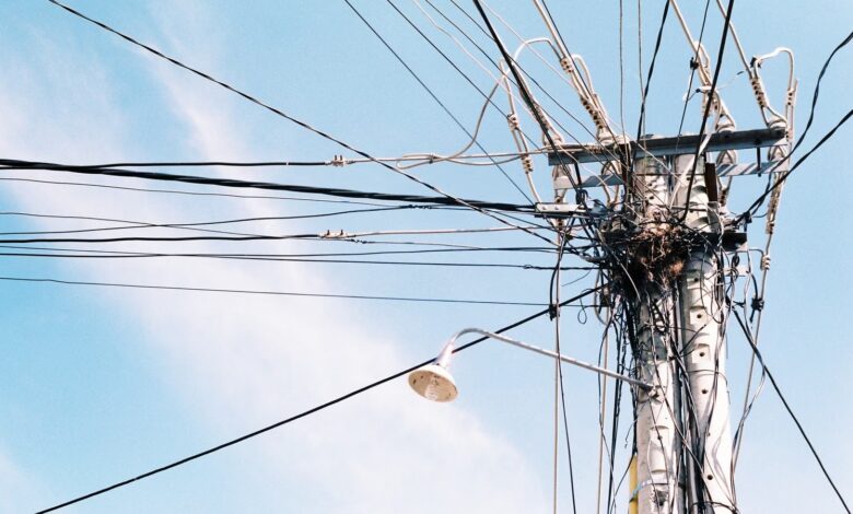 Poste de luz con cables de tendido eléctrico contra el cielo