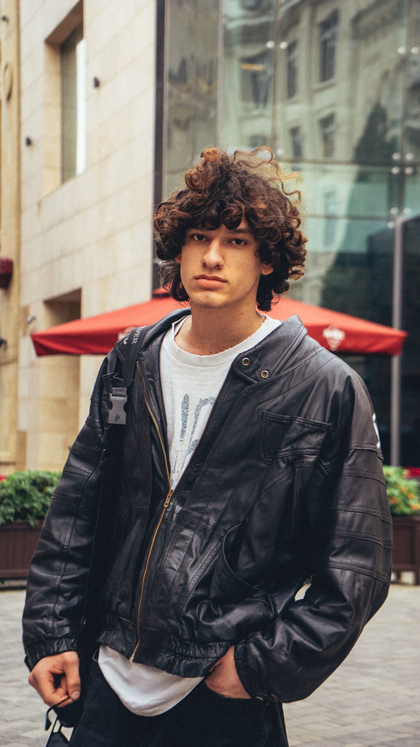 Joven con pelo rizado con volumen arriba y costados más cortos