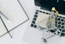 Carrito de compras en miniatura sobre una notebook