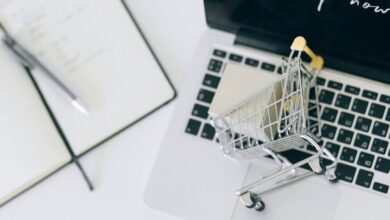 Carrito de compras en miniatura sobre una notebook