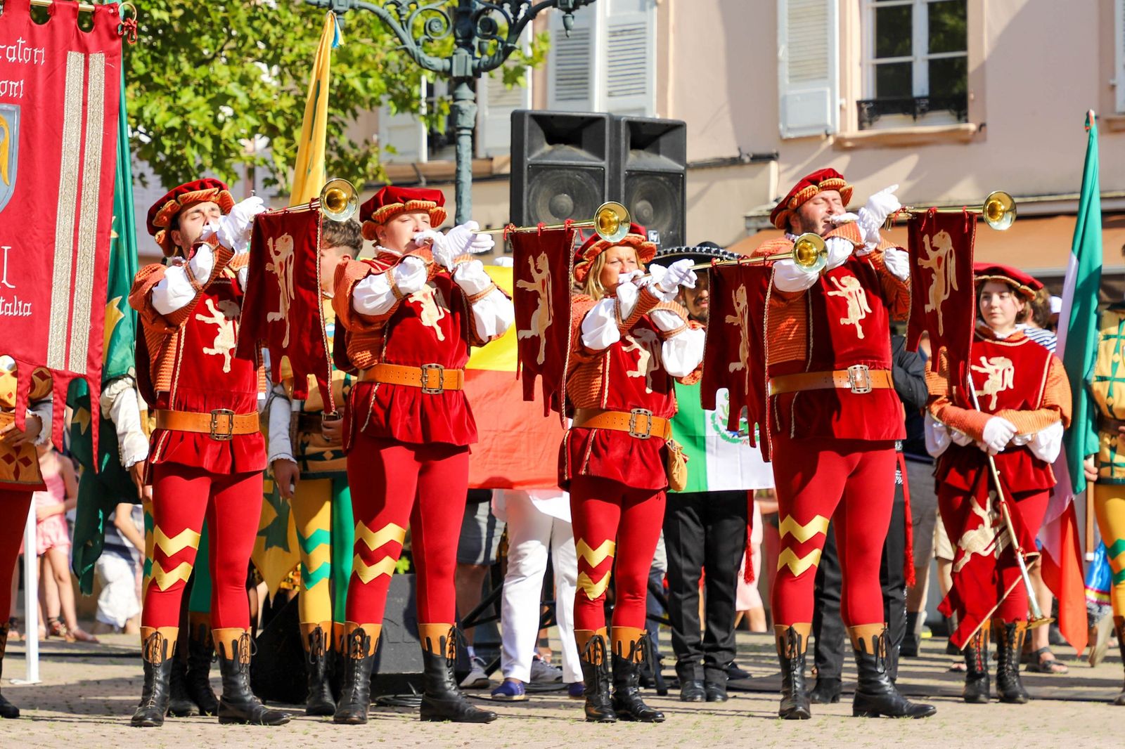 Músicos con trajes de estilo medieval rojos durante un desfile