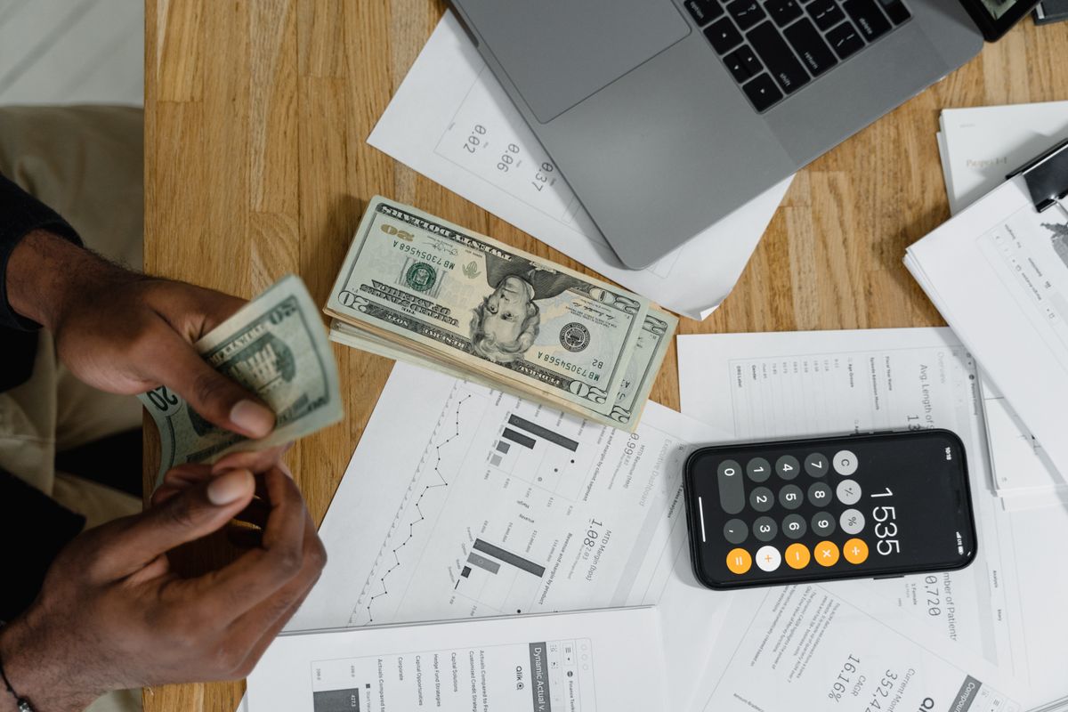 Manos con calculadora y gráficos mientras se revisan las cuentas