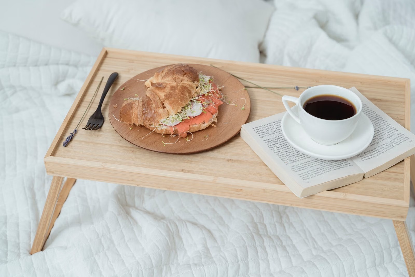 Bandeja de desayuno con café y tostado sobre una cama