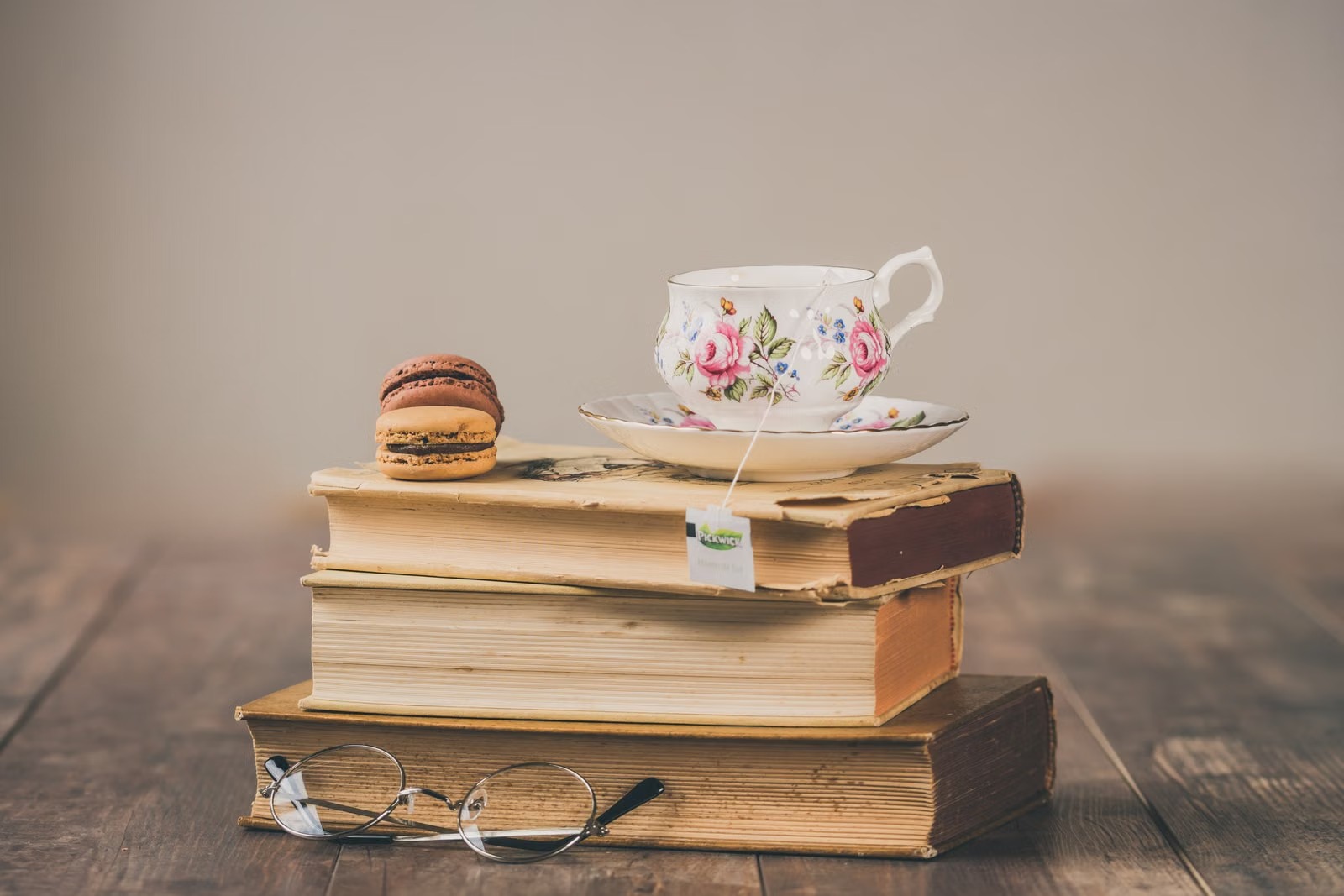 Pila de libros con una taza de té sobre una mesa