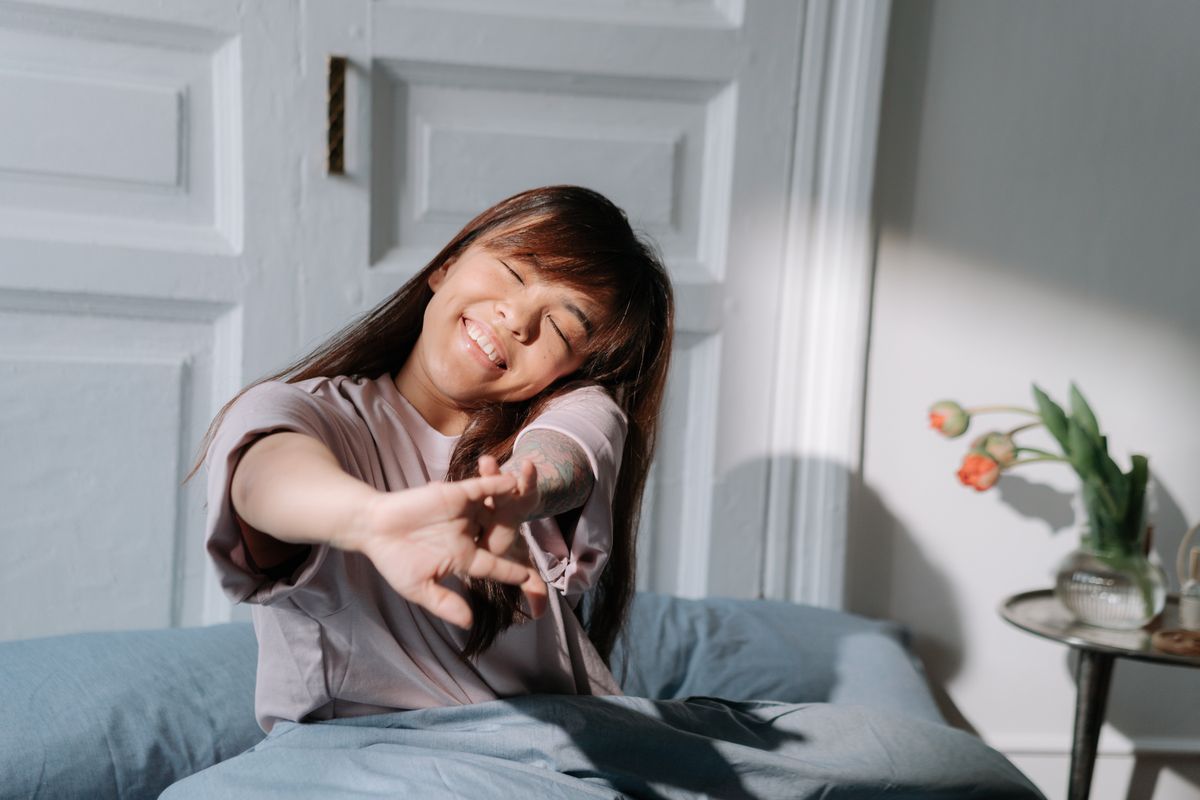 Mujer despertándose por la mañana en la cama