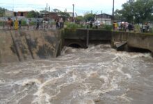 Arroyo Ludueña crecido en Rosario, con vecinos mirando el agua desde la baranda