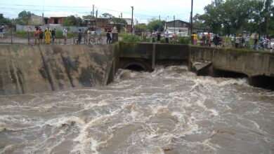 Arroyo Ludueña crecido en Rosario, con vecinos mirando el agua desde la baranda