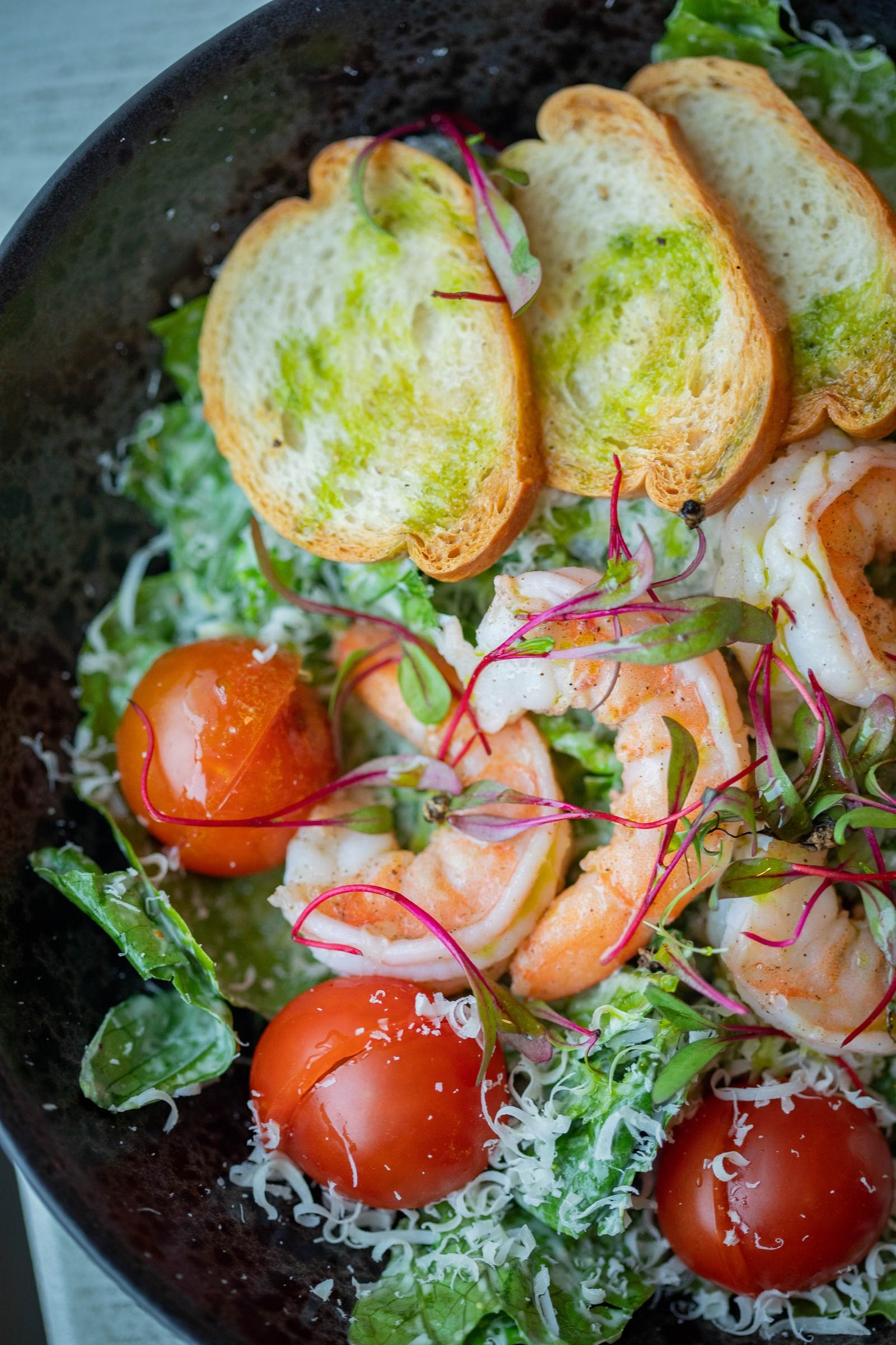 Ensalada de hojas verdes con frutas y pan tostado
