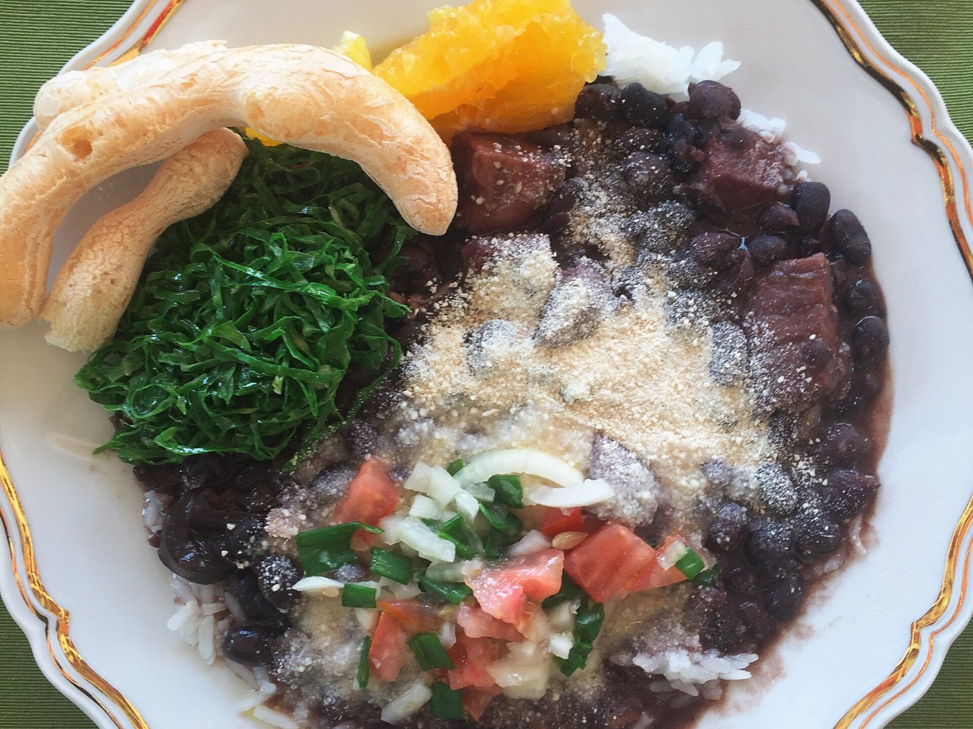 Plato de feijoada con arroz, verduras y farofa