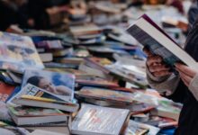 Personas recorriendo mesas con libros en una feria del libro