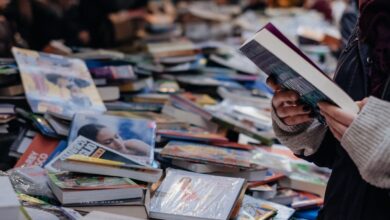 Personas recorriendo mesas con libros en una feria del libro