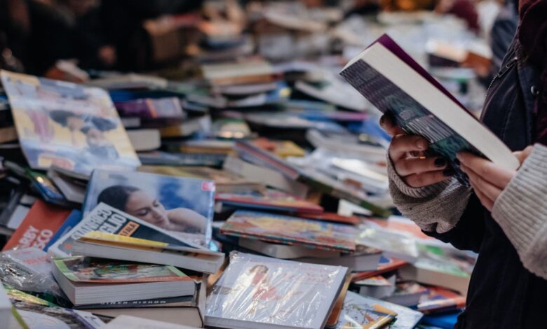 Personas recorriendo mesas con libros en una feria del libro