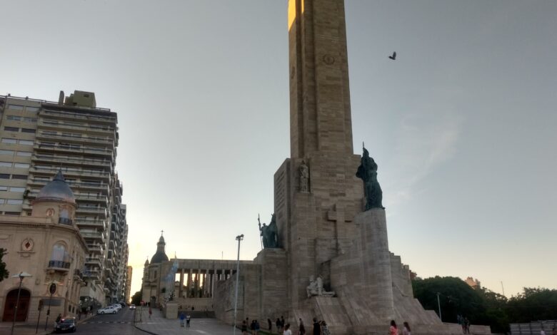 El Monumento Nacional a la Bandera de Rosario al atardecer, con el pasaje Juramento y edificios del centro a la izquierda