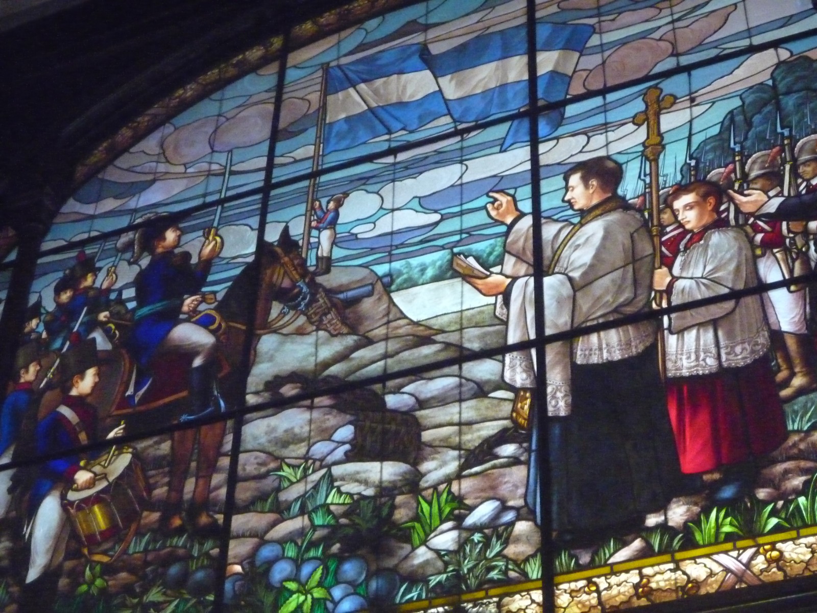 Vitral de la Catedral de Rosario con una escena histórica y la bandera argentina en el cielo