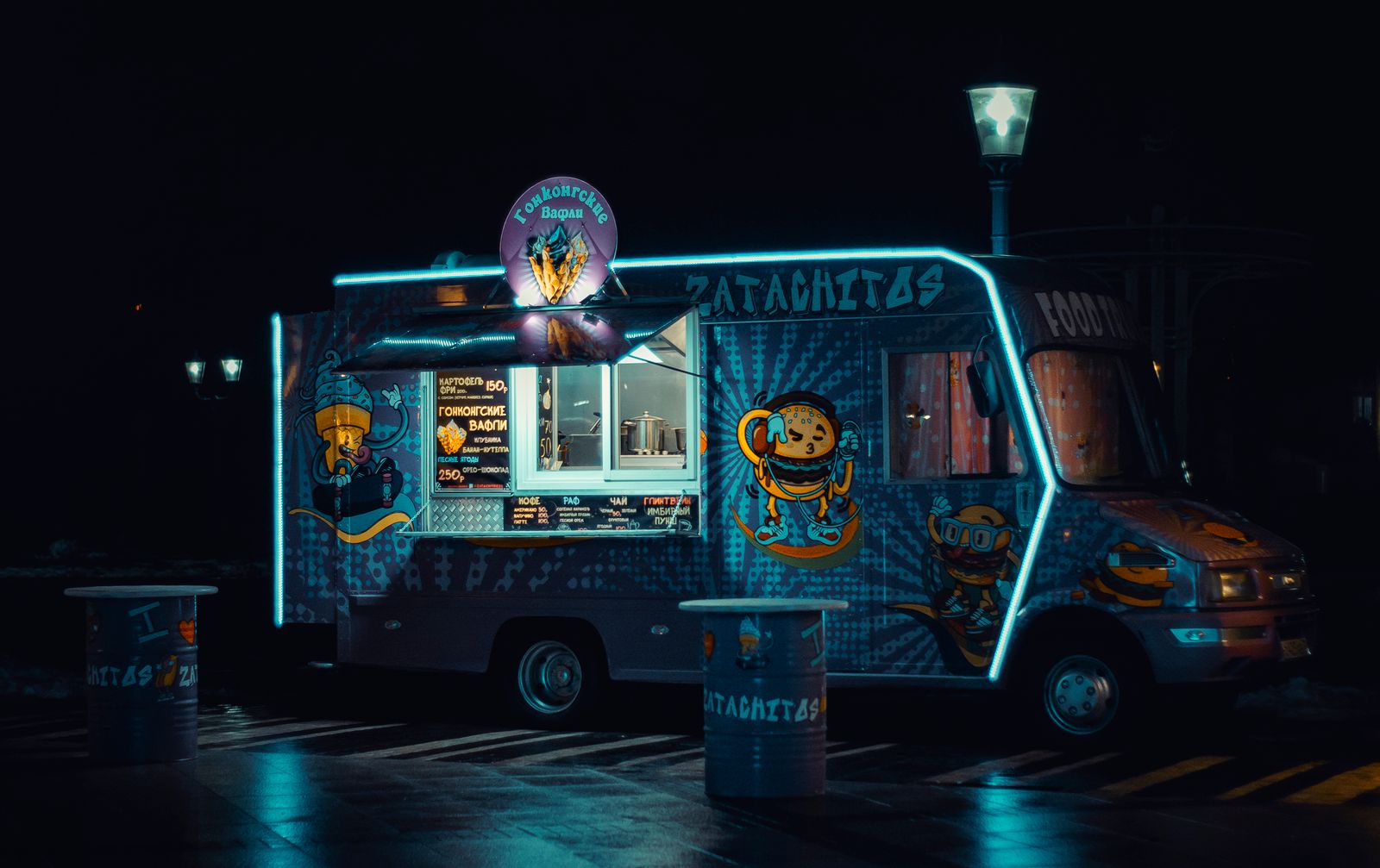 Foodtruck iluminado con luces de neón atendiendo de noche