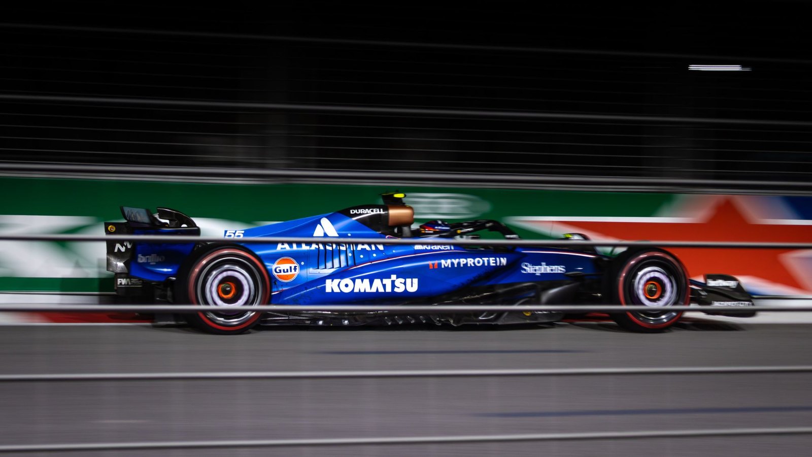 Auto de Fórmula 1 azul pasando a gran velocidad