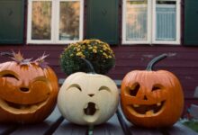 Tres calabazas talladas con caras sobre una mesa de madera