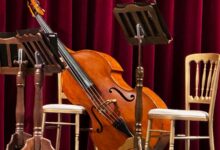 Escenario con violonchelo, atriles y sillas listo para un concierto acústico