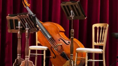 Escenario con violonchelo, atriles y sillas listo para un concierto acústico