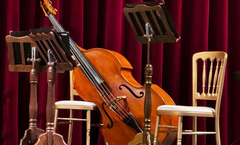 Escenario con violonchelo, atriles y sillas listo para un concierto acústico
