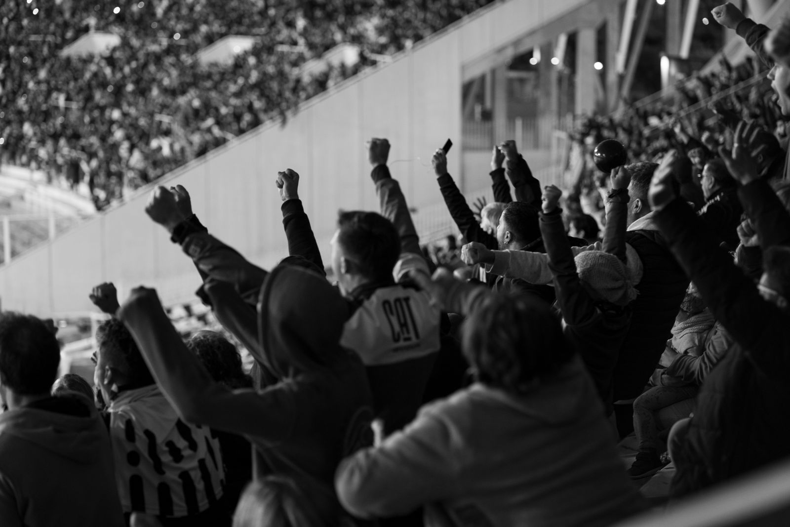 Hinchada alentando en la tribuna de un estadio de fútbol argentino