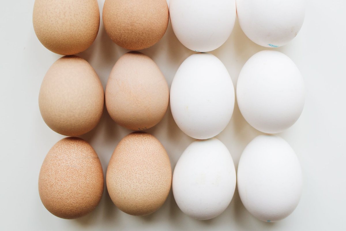 Huevos blancos y marrones sobre una superficie clara