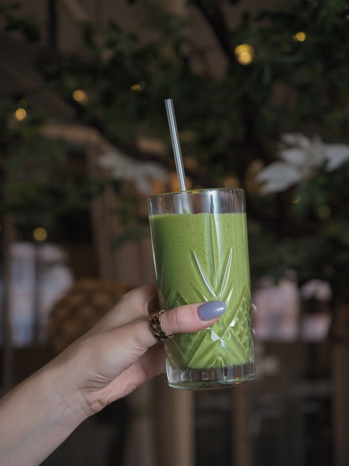Licuado verde en un vaso de vidrio tallado con sorbete