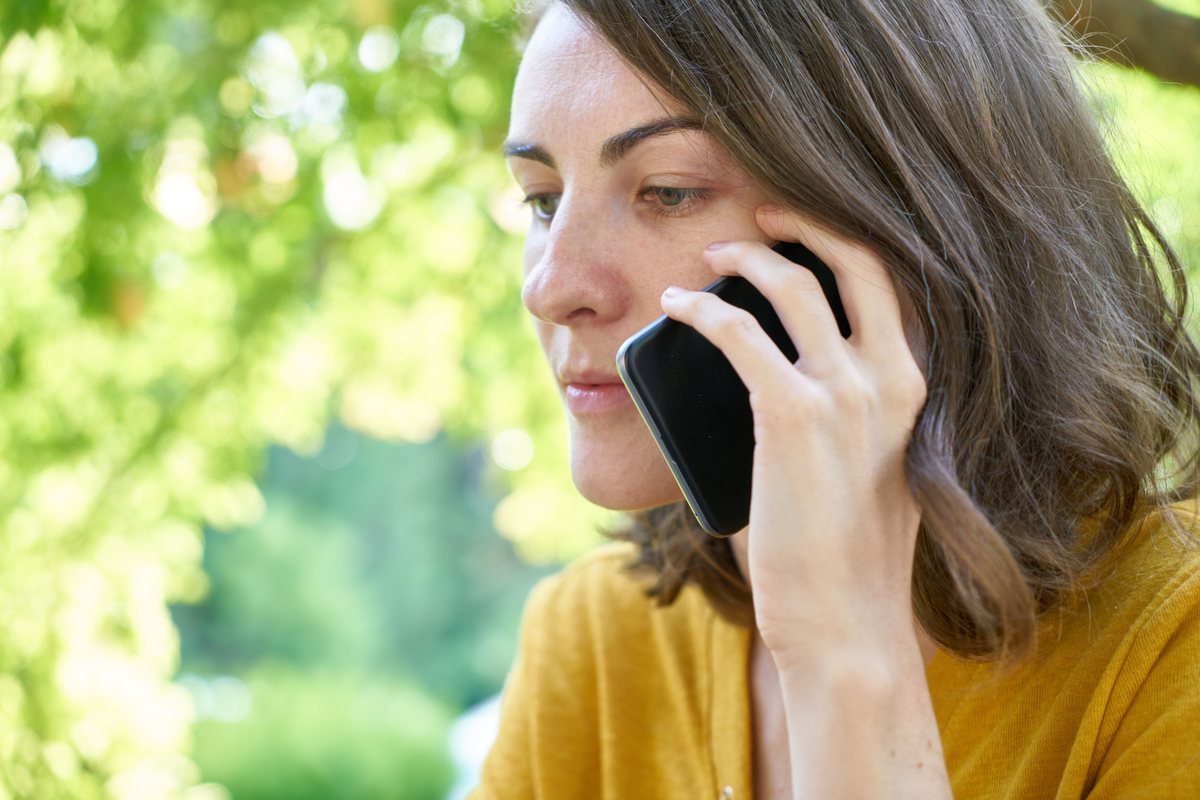 Mujer hablando por teléfono con gesto de desconfianza