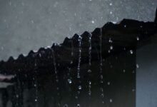Agua de lluvia cayendo desde el borde de un techo