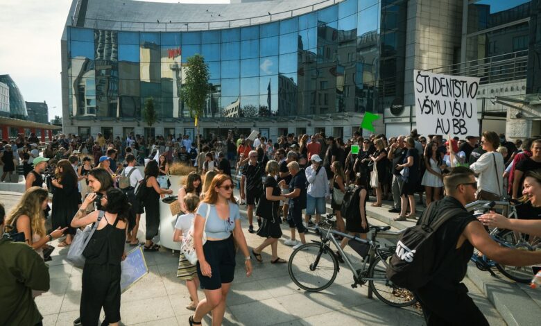 Estudiantes con carteles en una marcha frente a un edificio