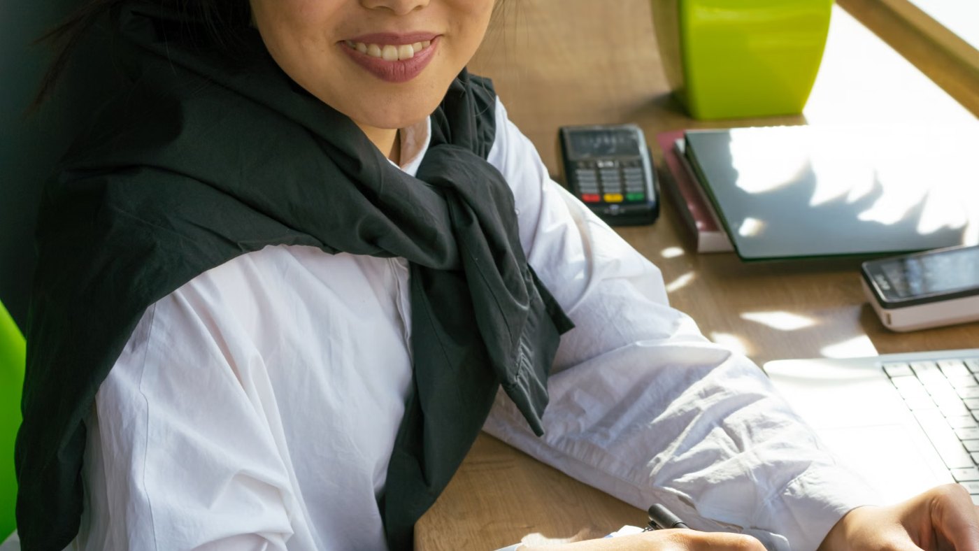 Mujer sonriendo frente a una notebook en una oficina
