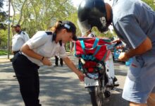 Agente municipal revisa la chapa patente de una moto durante un control en una calle arbolada de Rosario