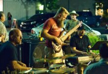 Banda tocando música en vivo en la calle de noche frente al público