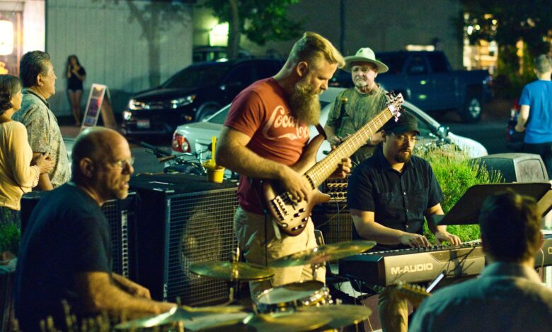 Banda tocando música en vivo en la calle de noche frente al público