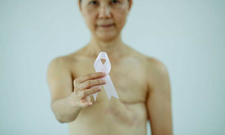 Mujer sostiene un lazo blanco de concientización sobre el cáncer de mama