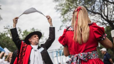 Pareja con trajes tradicionales bailando una zamba con pañuelo al aire libre en Rosario