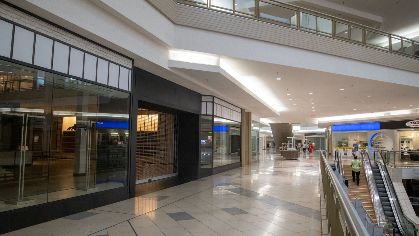 Pasillo de un centro comercial vacío con escaleras mecánicas