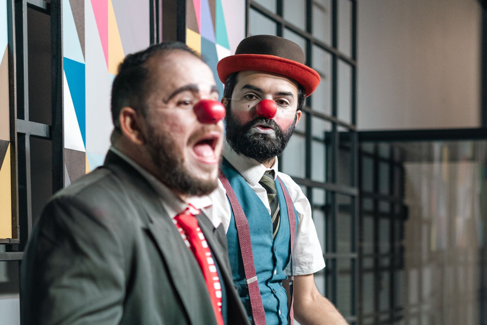 Dos payasos con nariz roja actúan de manera expresiva en un espectáculo