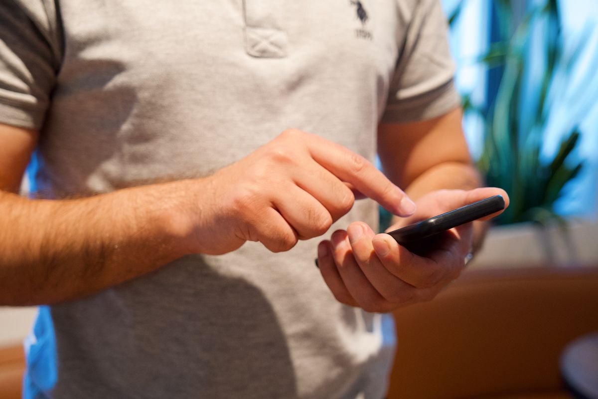 Manos sosteniendo un celular con aplicaciones abiertas