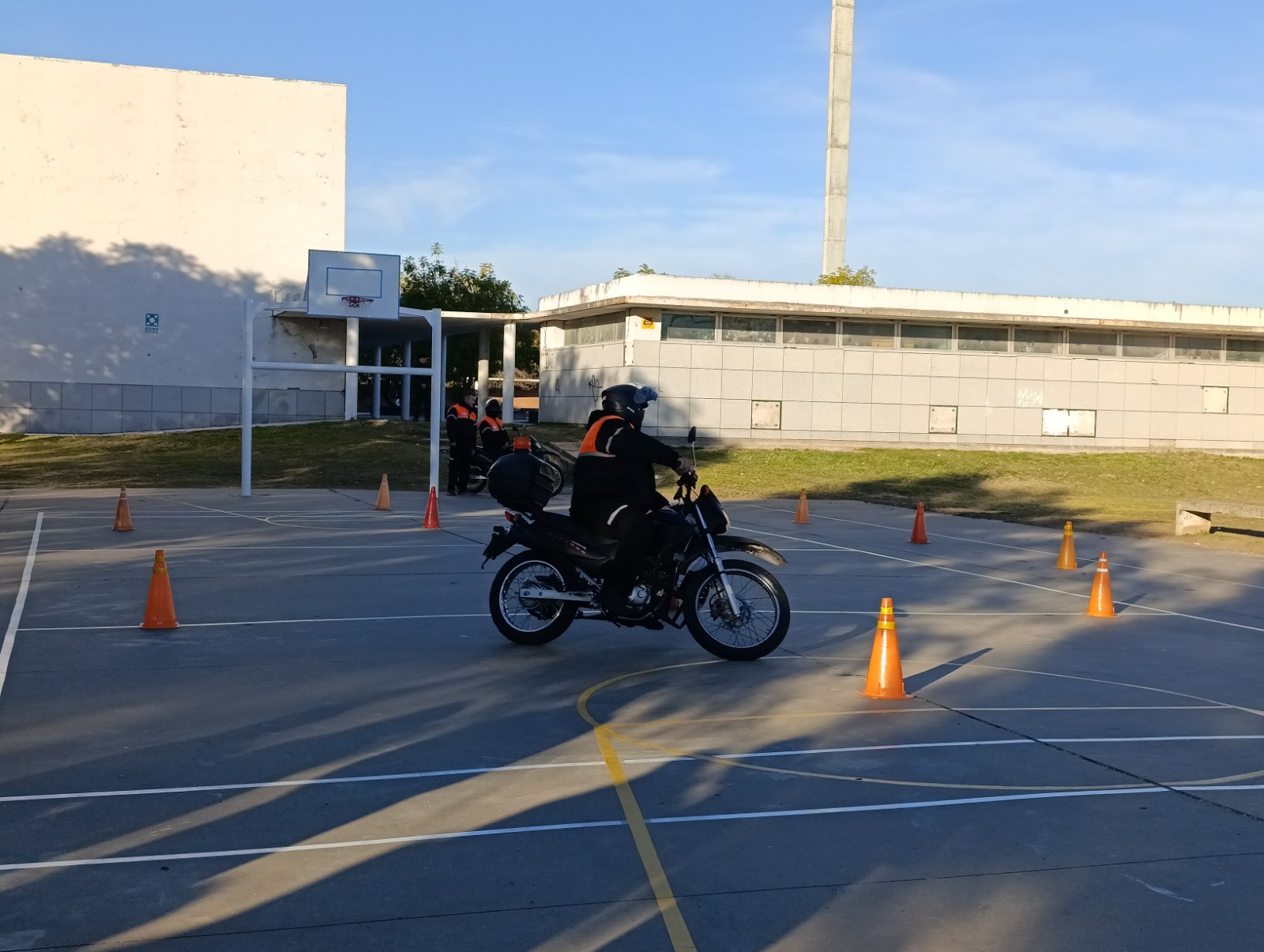 Motociclista rinde el examen práctico de la licencia de conducir en la pista con conos de un distrito municipal de Rosario